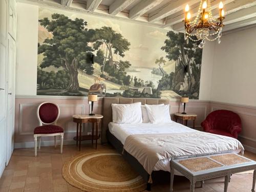 a bedroom with a bed and a painting on the wall at Maison D'hôtes Saint-Gildas in Beaufort-en-Vallée