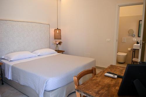 a bedroom with a bed and a table with a laptop at Il Monastero in Geremèas