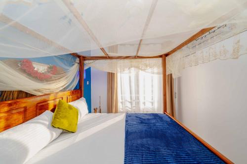 a bedroom with a bed with a yellow pillow on it at Zanzibar,Fumbatown 2 Bed Ocean view Apartment in Fumba