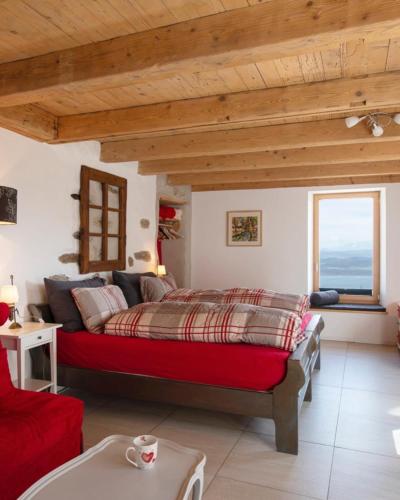 a bedroom with a red bed in a room at Maison d hôtes Les Bruyères in Bonvillars