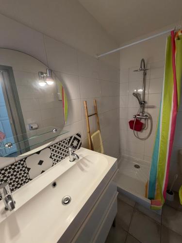 a white bathroom with a sink and a shower at Studio en plein cœur de Saint Florent in Saint-Florent