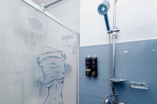 a bathroom with a shower with a drawing on the wall at Zanzibar,Fumbatown 2 Bed Ocean view Apartment in Fumba
