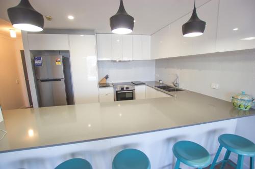 a kitchen with white cabinets and white counter tops at Carrington Court in Gold Coast
