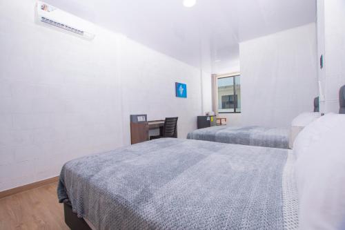 a hotel room with two beds and a desk at Hospedaje Zerimar Hab 7 in Puerto Baquerizo Moreno