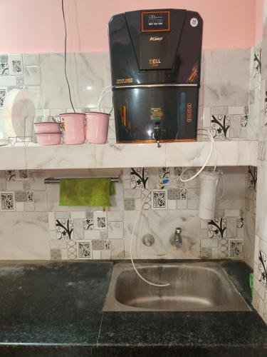 a kitchen with a sink and a coffee maker at Bhakti Suite in Deoghar