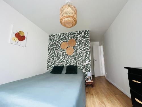 a bedroom with a bed with a patterned wall at Mon petit cocon auvergnat in Combronde