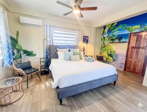 a bedroom with a bed and a painting on the wall at Costa Nube in Caye Caulker