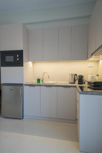 a kitchen with white cabinets and a sink at Gerania nature Residence 21 in Siátista
