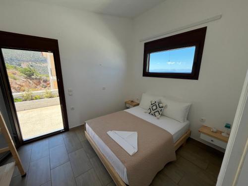 a small bedroom with a bed and a window at Nefeles View in rkadiko Chorio