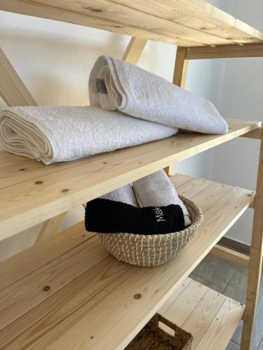 a shelf with towels and a basket of towels at Nefeles View in rkadiko Chorio
