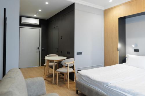 a bedroom with a bed and a table and chairs at Апарт-готель Select in Lviv