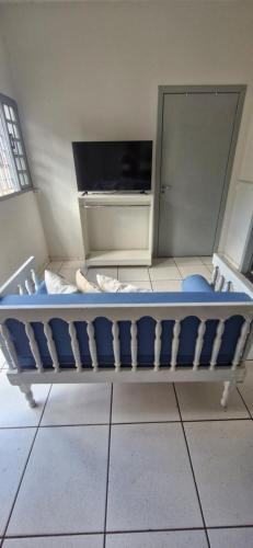 a blue bed in a room with a tv at Casa confortável em Tangará in Tangara da Serra