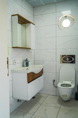 a white bathroom with a sink and a toilet at Türkmen Villa in Belek