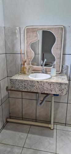 a bathroom with a sink and a mirror at Casa confortável em Tangará in Tangara da Serra