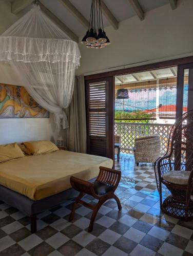a bedroom with a bed and a chair at Studio Frangipani dans Villa Fleurs des Iles in Le Vauclin