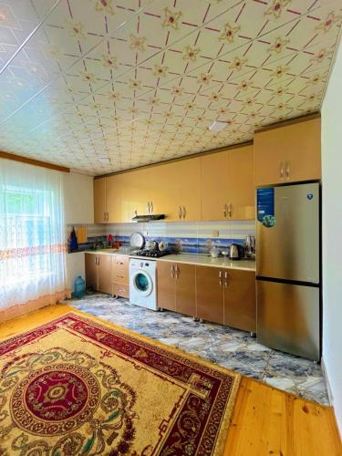 a kitchen with a refrigerator and a washer and dryer at Sweet home in Lerik