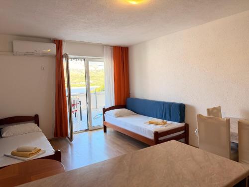 a room with a couch and a bed and a window at Apartments TORO Pag in Pag