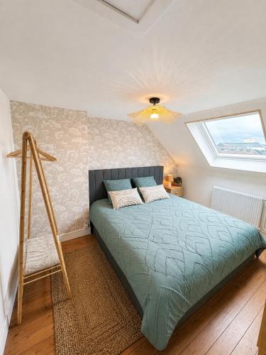 a bedroom with a bed in a room with a window at Évasion Aubinoise, charmant duplex in Saint-Aubin-lès-Elbeuf