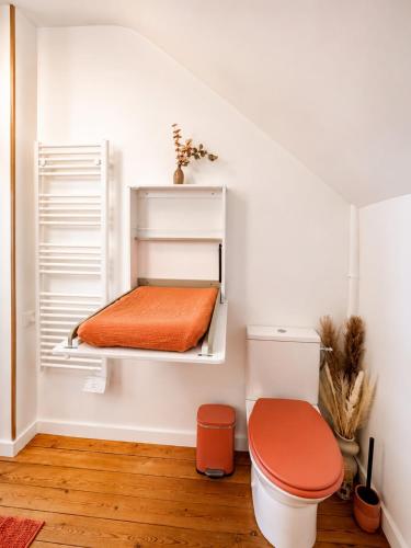 a room with a toilet and an orange pillow at Évasion Aubinoise, charmant duplex in Saint-Aubin-lès-Elbeuf