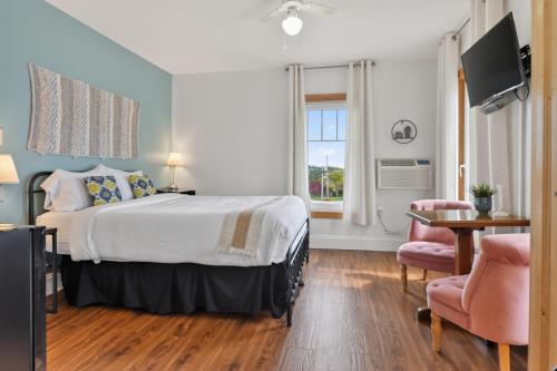 a bedroom with a bed and a table and a chair at Pepperell Place Inn Inc. in St. Peter's