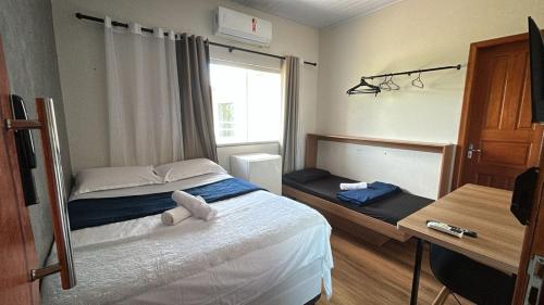 a small bedroom with a bed and a desk at Flat hotel Victoram in Rio Branco