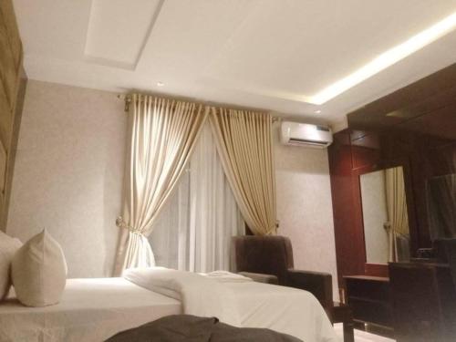 a hotel room with two beds and a window at Charles Stainless Hotels in Abakaliki