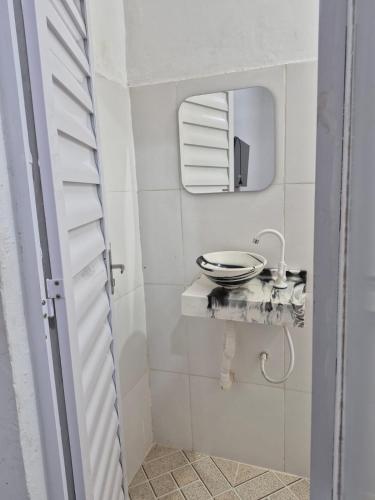 a white bathroom with a sink and a mirror at Manancial de Aguas V in Barreirinhas