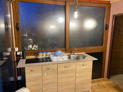 a kitchen with a sink and a large window at Kućica Pirata in Ulcinj
