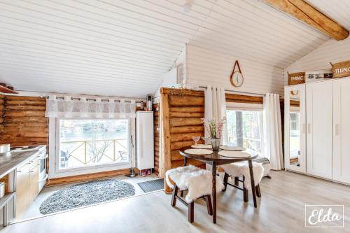 a kitchen with a table and chairs in a room at Paraisten Helmi in Lönäs