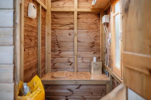 a wooden bathroom with a shower in a room at Olívia, Caravana Vintage, Castelo de Vide in Castelo de Vide