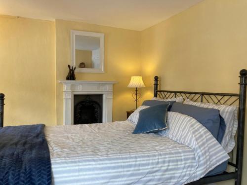 a bedroom with a bed with a fireplace and a mirror at Historic maisonette cottage in Cuckfield