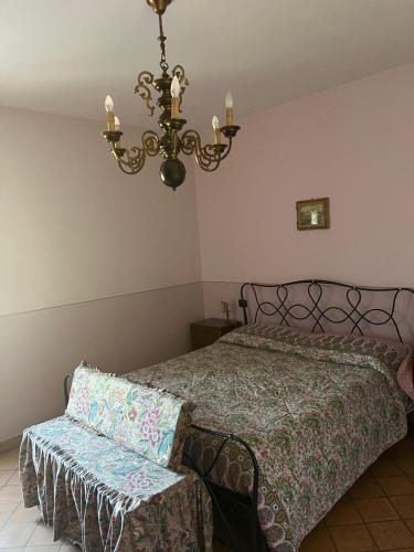 a bedroom with a bed and a chandelier at Casa Vacanze Masseria Tidei in Sant'Agata de' Goti