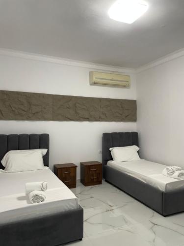 a room with two beds and two night stands at Vila JONI in Berat