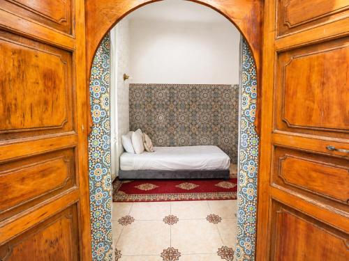 a bedroom with a bed in a room with a door at Riad O LY in Marrakesh