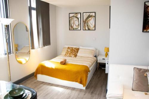 a small bedroom with a bed and a mirror at Stylish Studio in the Heart of Sheffield in Sheffield