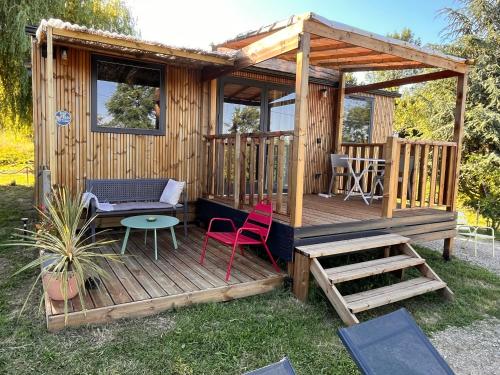 a wooden cabin with two chairs and a table and a table at O'BARA Lodge - Tiny House - Jardin et climatisation in Druillat