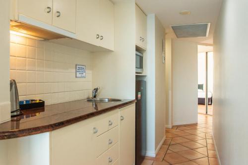 a kitchen with a sink and a counter at La Promenade Absolute Waterfront Apartments in Caloundra