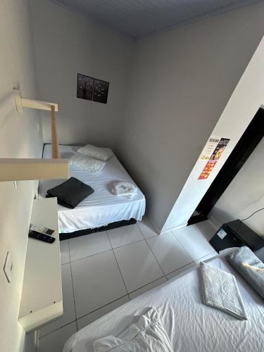 a small room with two beds and a staircase at Hotel São Miguel in Posse
