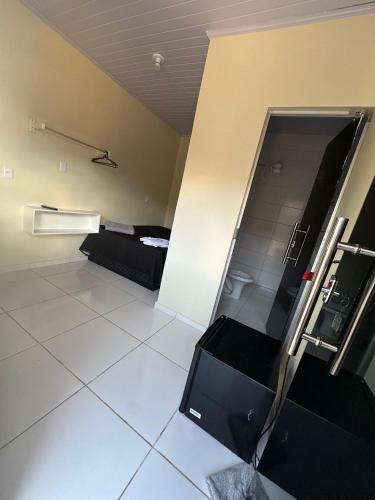an empty room with a large white tile floor at Hotel São Miguel in Posse