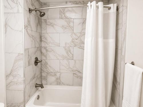 a bathroom with a shower with a white shower curtain at Torraille Waterfall Villas in Soufrière