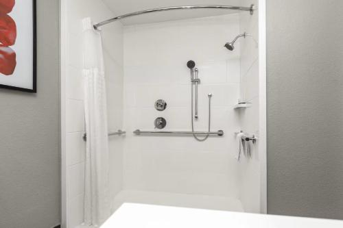 a bathroom with a shower with a shower curtain at Hawthorn Extended Stay by Wyndham DFW Airport North in Irving