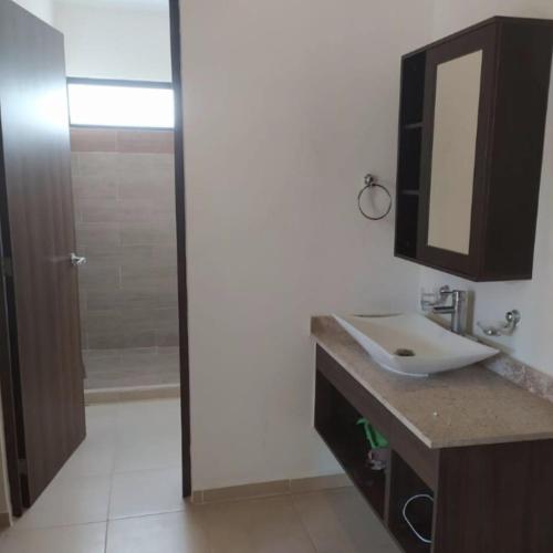 ein Badezimmer mit Waschbecken, Spiegel und Dusche in der Unterkunft Hermosa Casa de 4 habitaciones en Tixcacal, Mérida in Tixcacal