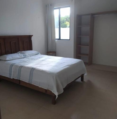 ein Schlafzimmer mit einem großen Bett und einem Fenster in der Unterkunft Hermosa Casa de 4 habitaciones en Tixcacal, Mérida in Tixcacal