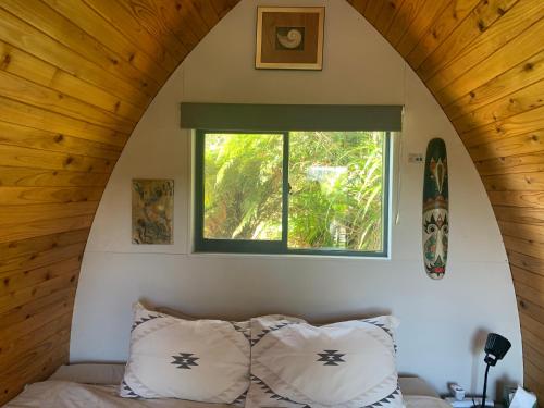 a bedroom with a window and a bed with pillows at The Dome Waikino in Waikino