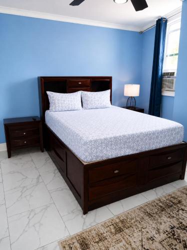 a bedroom with a bed with a blue wall at Torraille Waterfall Villas Main Suites in Soufrière