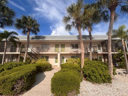 an exterior view of a building with palm trees at Shark tooth Condo in Venice