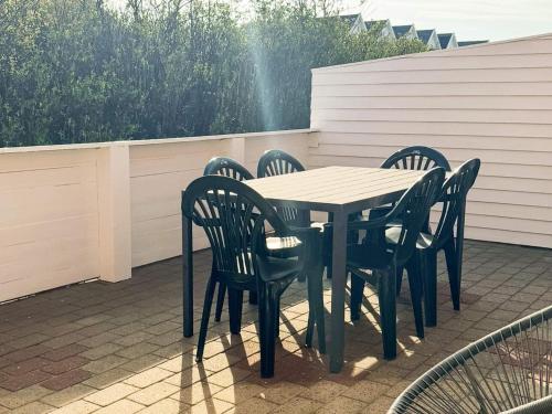 a wooden table and chairs on a patio at 6 person holiday home in Rømø-By Traum in Sønderby