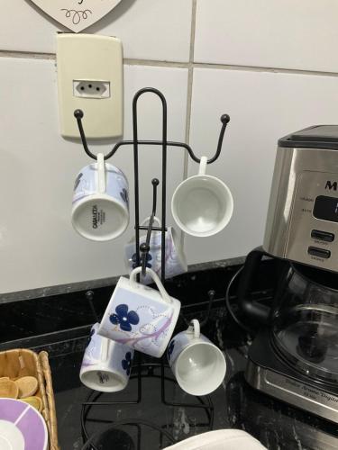 a kitchen with three lights and a coffee maker at Ap com 2 quartos climatizados , com fechadura eletrônica, WI-FI ,condomínio Village do bosque 3 in Imperatriz
