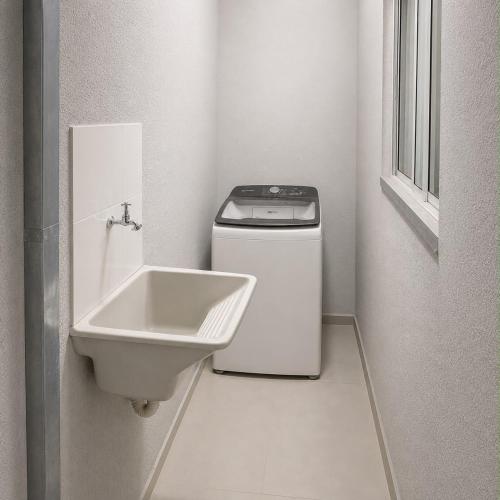 a small white bathroom with a sink and a washer at Anápolis city in Anápolis