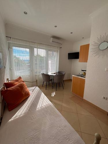 a bedroom with a bed and a kitchen with a table at Apartmani Znaor in Baška Voda